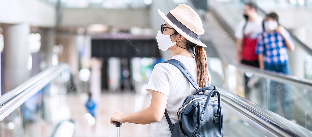 Mulher adulta jovem usando máscara facial no terminal do aeroporto