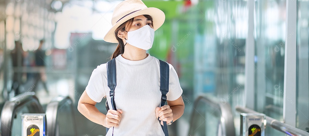 Mulher adulta jovem usando máscara facial no terminal do aeroporto