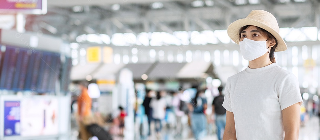 Mulher adulta jovem usando máscara facial no terminal do aeroporto