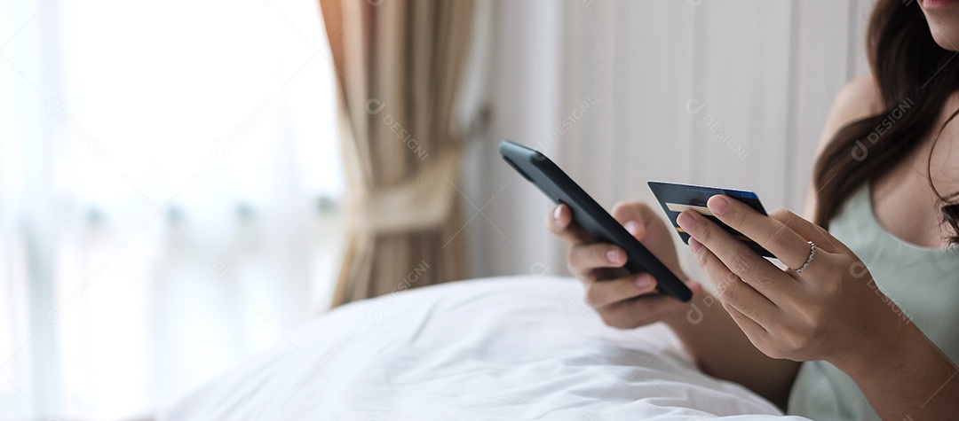 Mulher feliz segurando cartão de crédito e usando celular