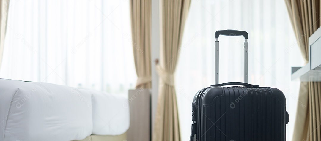Bagagem preta no quarto de hotel moderno com janelas, cortinas
