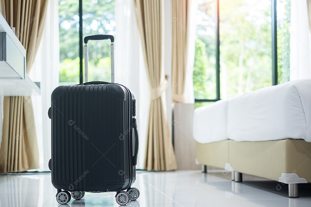 Bagagem preta no quarto de hotel moderno com janelas, cortinas