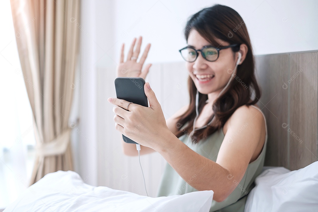 Feliz mulher casual fazendo videochamadas pelo smartphone em casa
