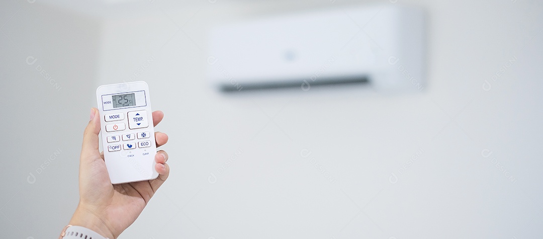 mão usando o controle remoto para ajustar o condicionador de ar