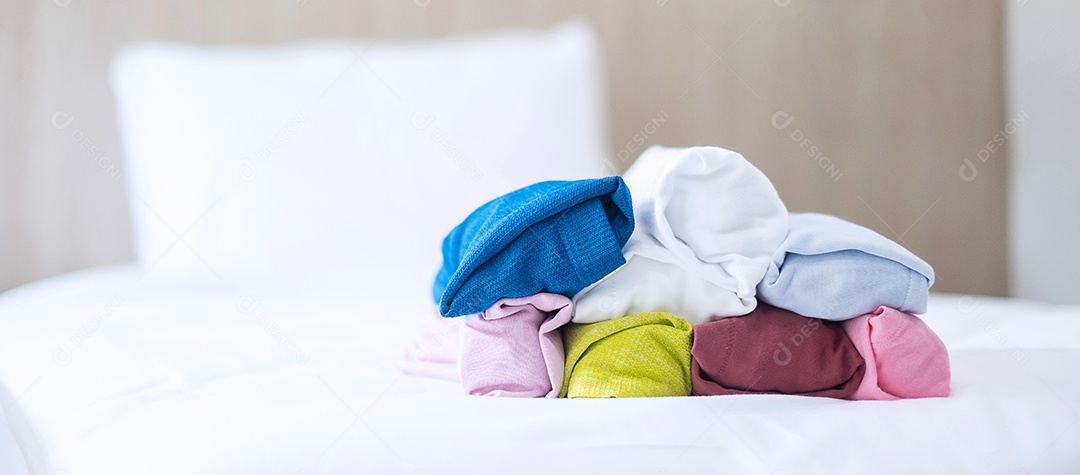 Pilha de camiseta colorida na cama em hotel de luxo ou resort ou ho