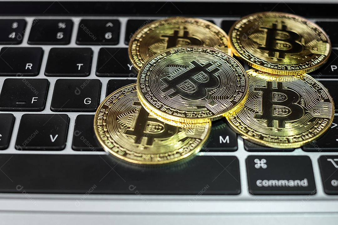 pilha de moedas de criptomoeda Bitcoin dourada no teclado do laptop