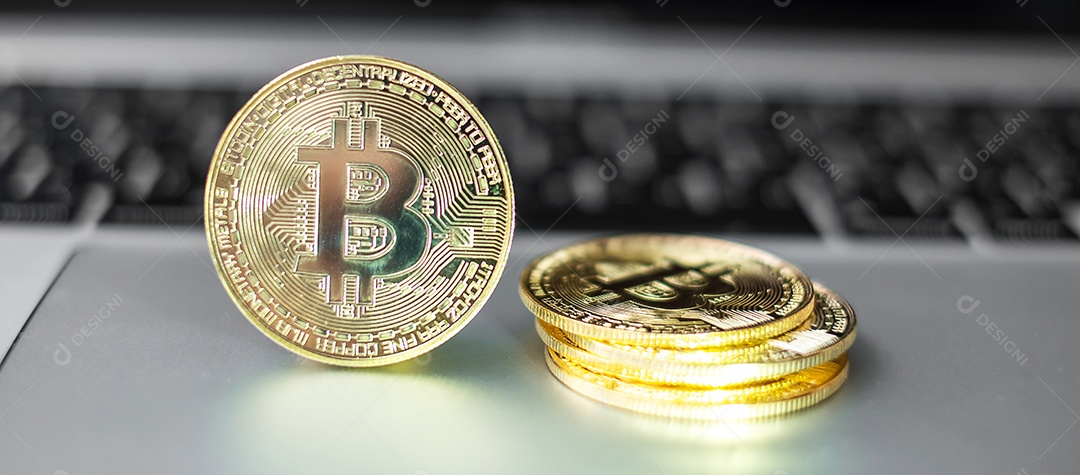 pilha de moedas de criptomoeda Bitcoin dourada no teclado do laptop
