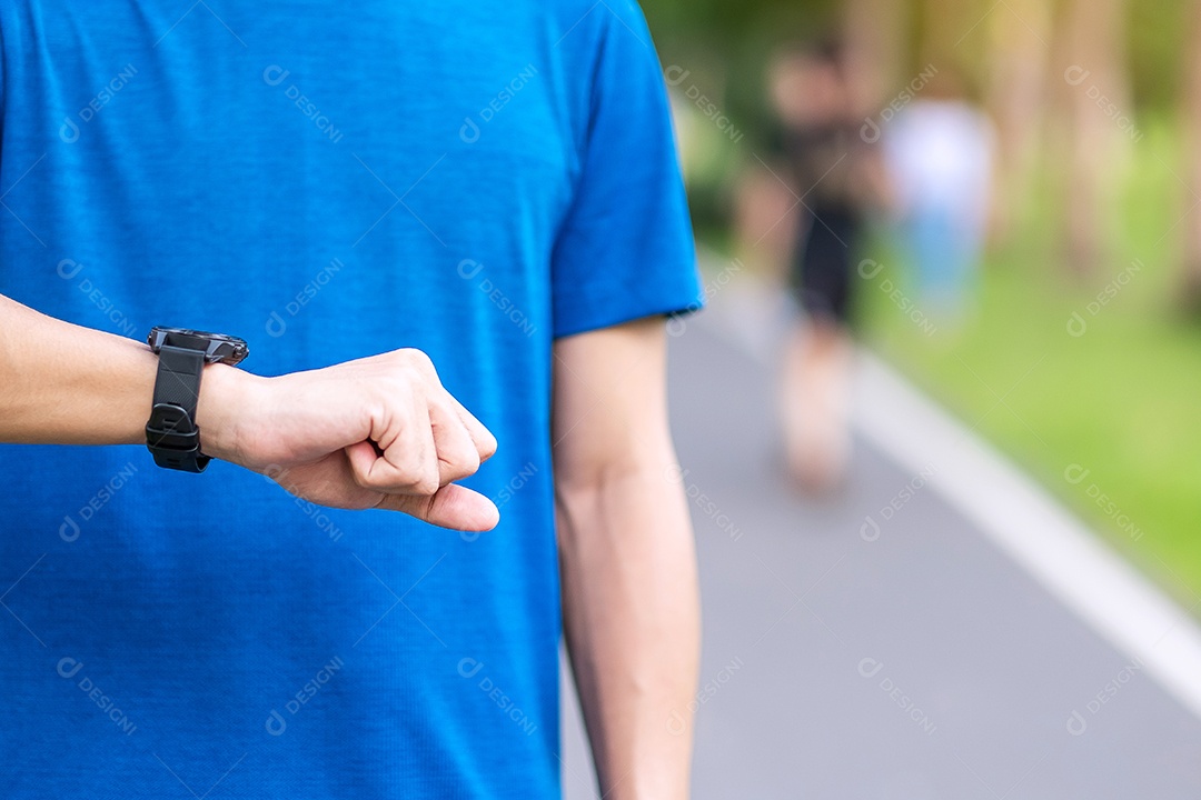 Macho adulto jovem verificando o tempo e a frequência cardíaca cardio no esporte sm