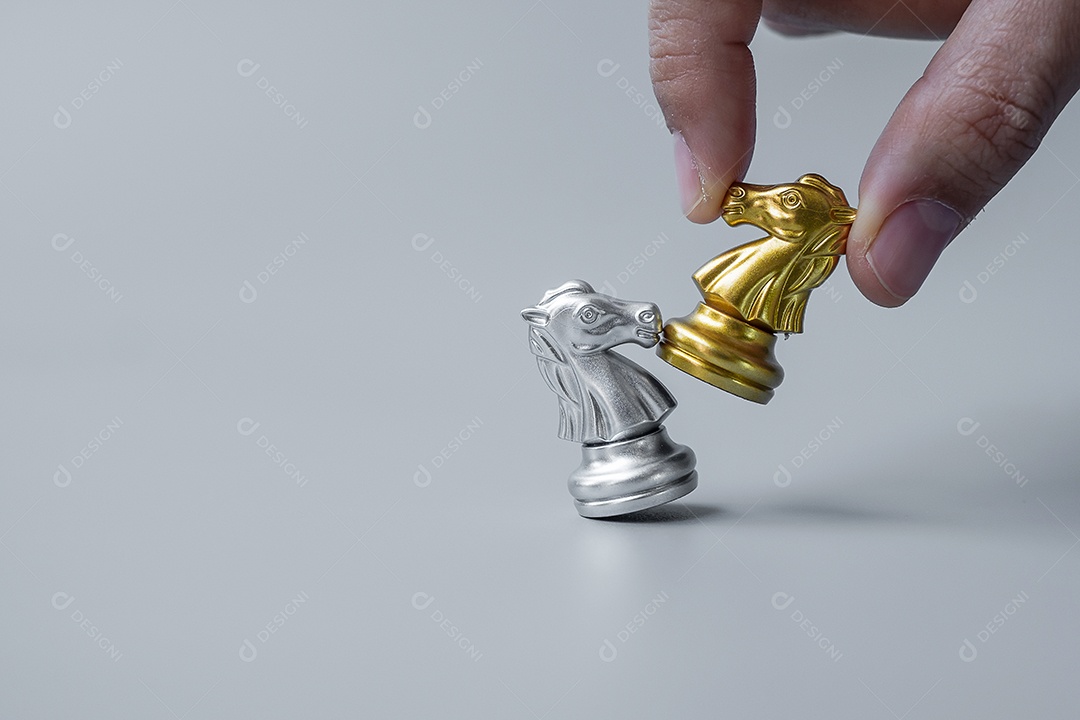 mão de empresário movendo ouro Chess Knight (cavalo) figura