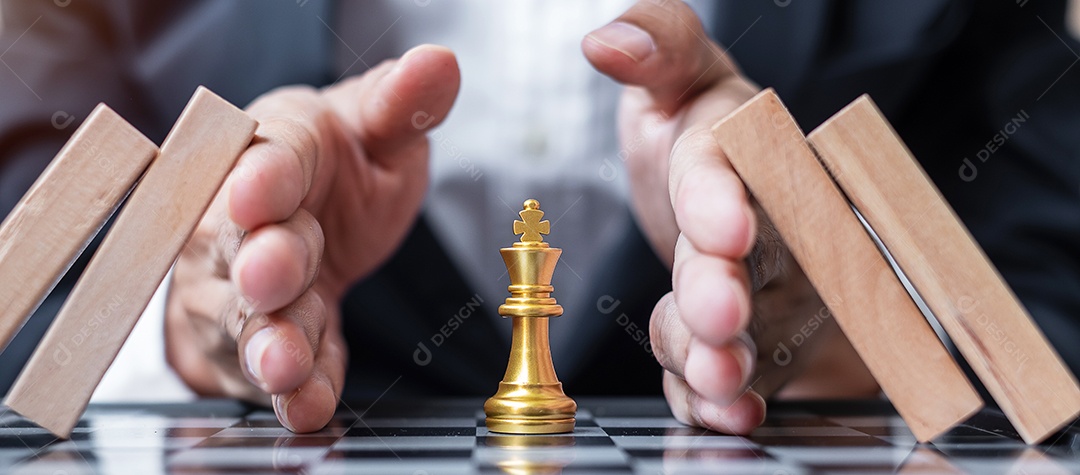 Businessman hand protects Chess King figure and Stopping Falling
