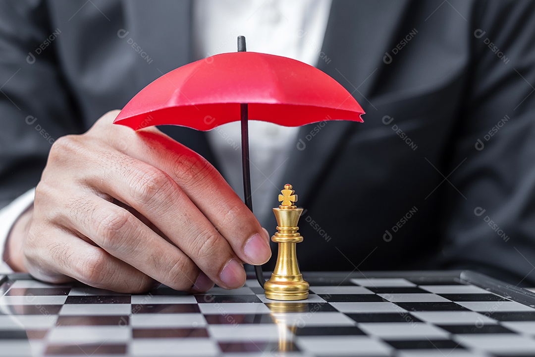 Mão de homem de negócios segurando o guarda-chuva vermelho figura Chess King.