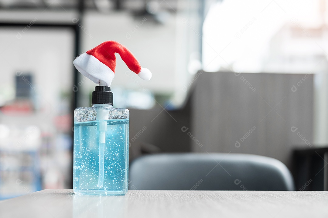 Feliz Natal com chapéu de Papai Noel e desinfetante para as mãos de lavagem