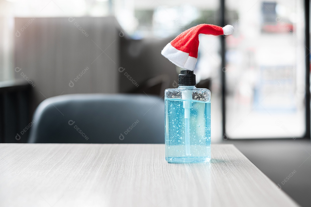 Feliz Natal com chapéu de Papai Noel e desinfetante para as mãos de lavagem