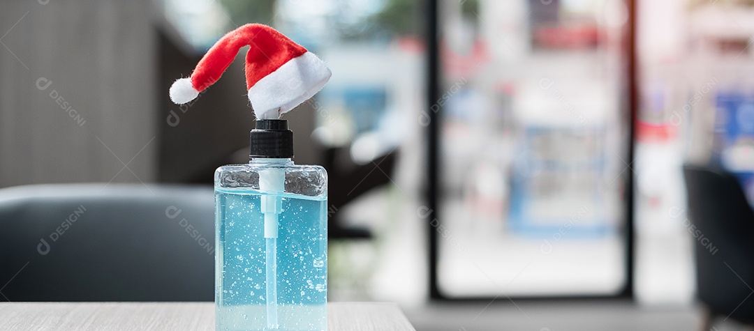 Feliz Natal com chapéu de Papai Noel e desinfetante para as mãos de lavagem