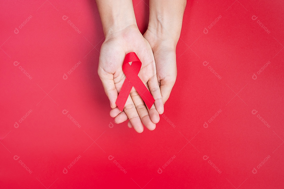 Mão segurando a fita vermelha para apoiar as pessoas que vivem e estão doentes. Saúde e conceito de sexo seguro. Dezembro Dia Mundial da Aids e Mês de Conscientização do Câncer do Mieloma Múltiplo
