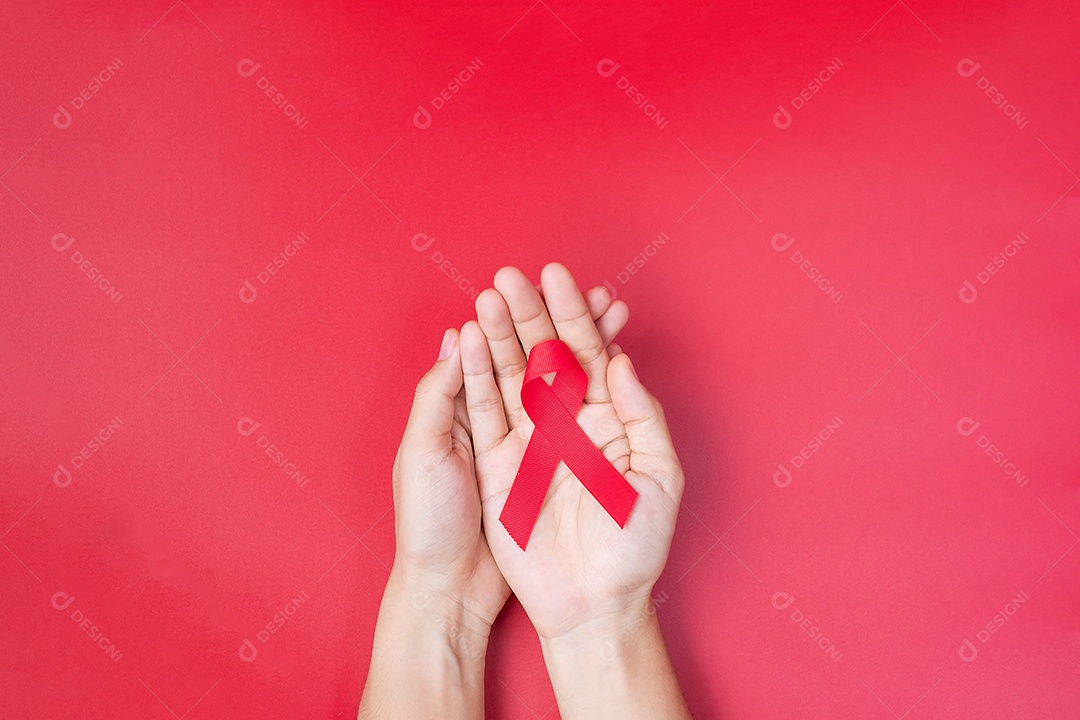 Mão segurando a fita vermelha para apoiar as pessoas que vivem e estão doentes. Saúde e conceito de sexo seguro. Dezembro Dia Mundial da Aids e Mês de Conscientização do Câncer do Mieloma Múltiplo