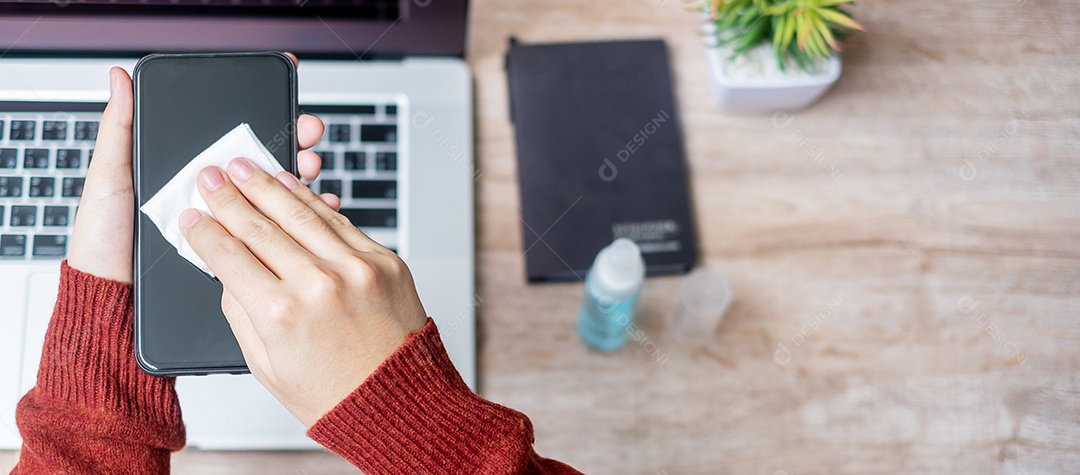 Mulher limpando smartphone e laptop por lenços umedecidos e alc