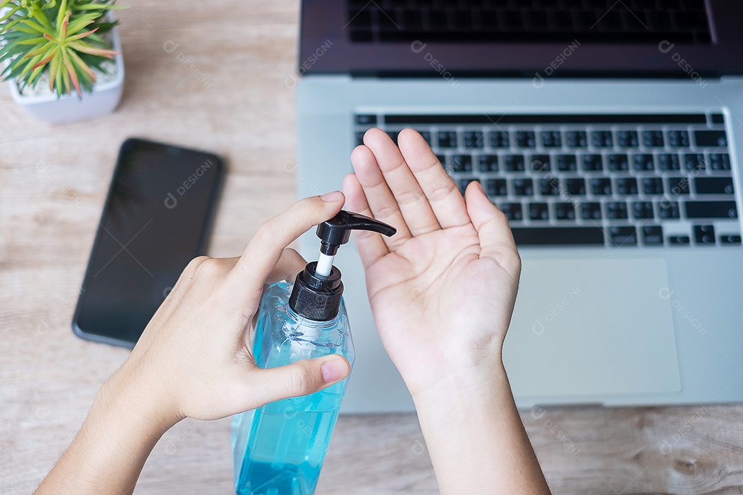 Mulher limpando as mãos por desinfetante de gel de álcool sobre laptop e sm