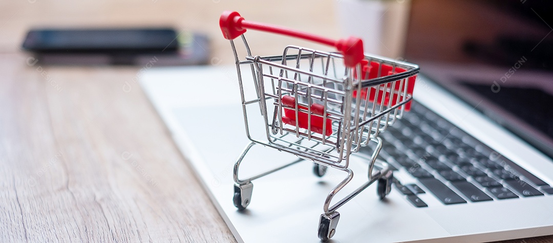 Carrinho de compras no laptop no escritório em casa. negócios, e-business