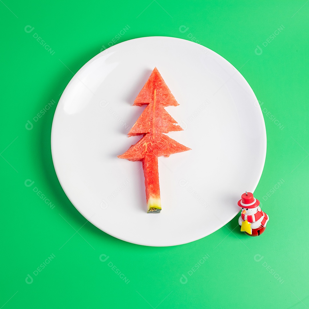 Árvore de natal de melancia com garfo e faca em fundo verde