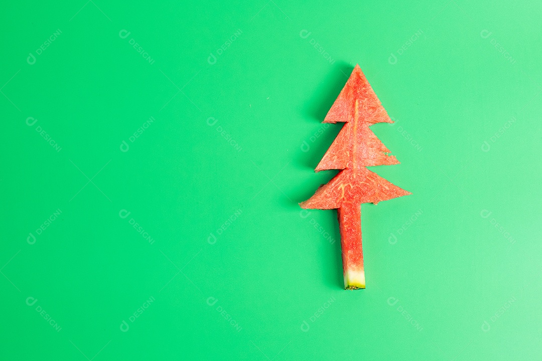 Árvore de natal de melancia com garfo e faca em fundo verde