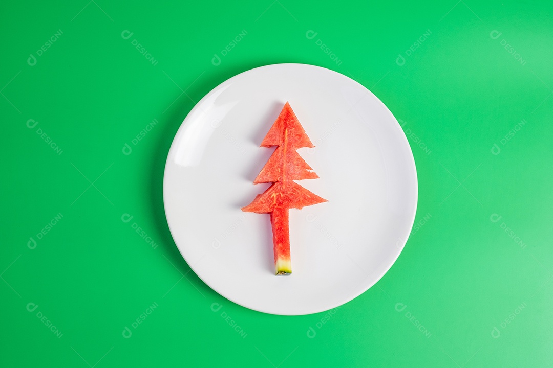 Árvore de natal de melancia com garfo e faca em fundo verde