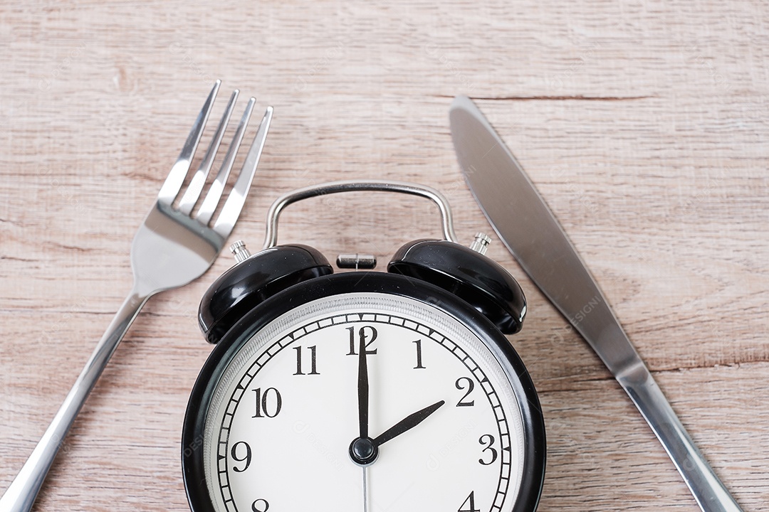 Vista superior despertador com faca e garfo na mesa de madeira background