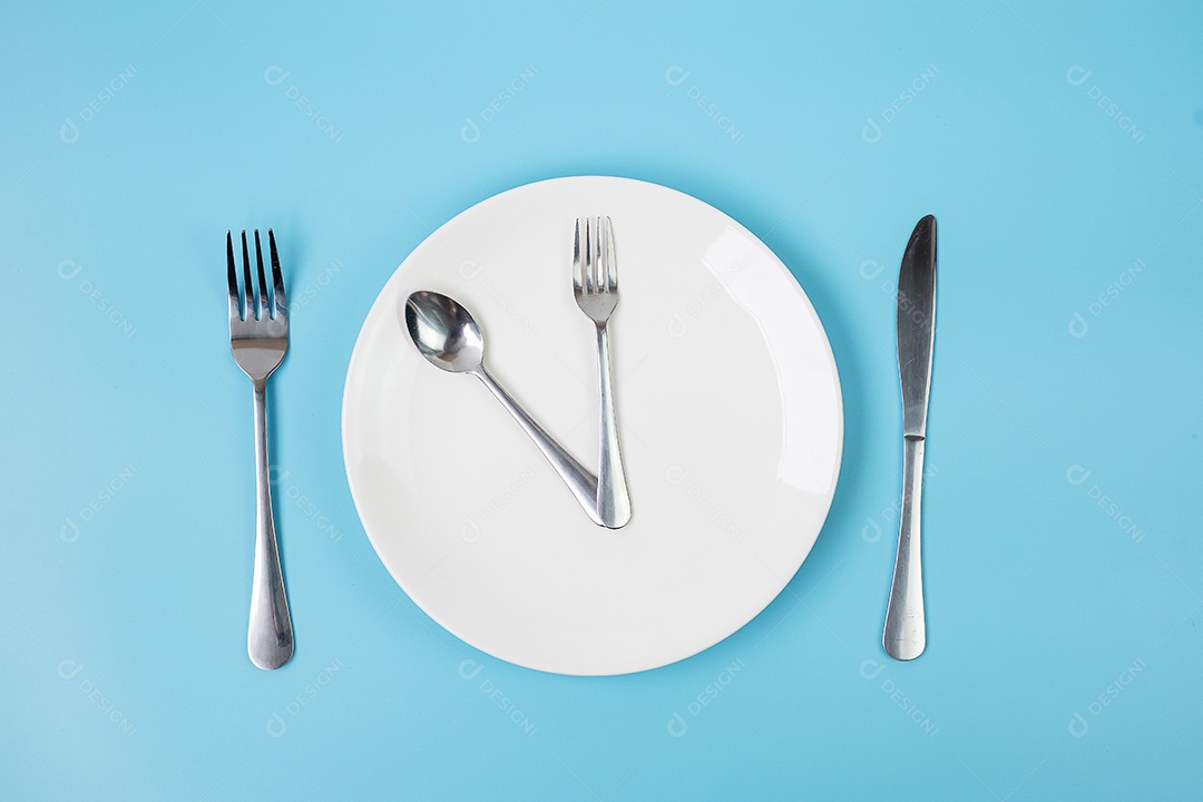 Vista superior placa cerâmica branca com faca, colher e garfo em azul