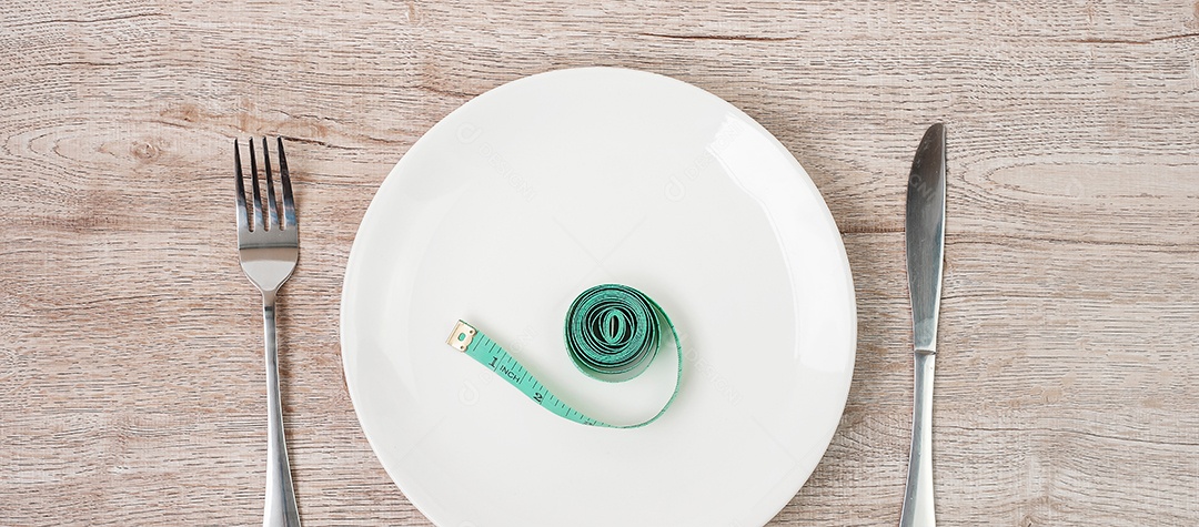 Vista superior Fita métrica verde enrolada em garfo e faca