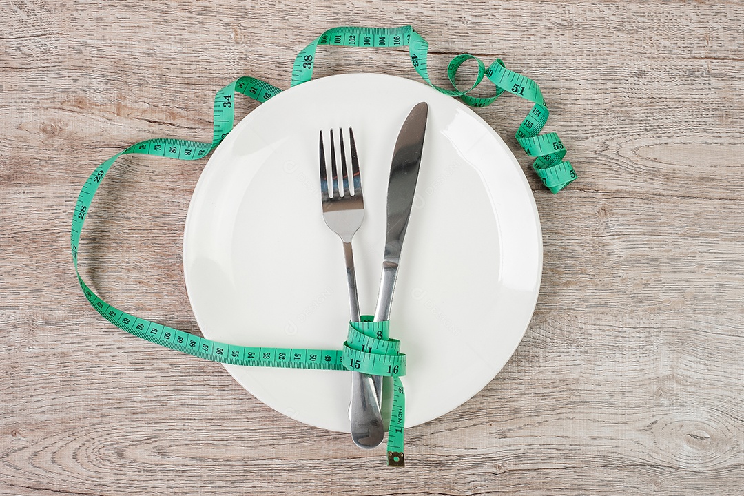 Vista superior Fita métrica verde enrolada em garfo e faca