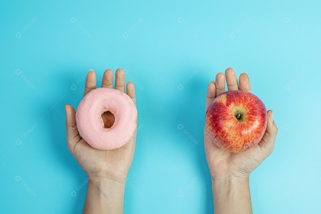 mulher segurando maçã vermelha e rosquinha rosa, a fêmea escolhe entre frutas é comida saudável e doce é junk food não saudável