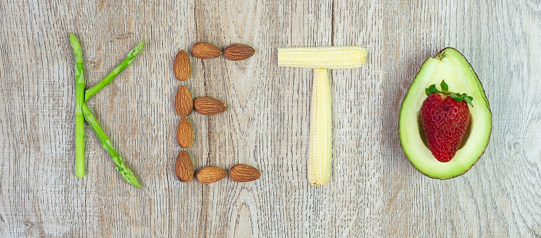 Arranjo KETO de aspargos orgânicos, amêndoa, milho bebê e abacate com morango no fundo da mesa. perda de peso, alimentação saudável