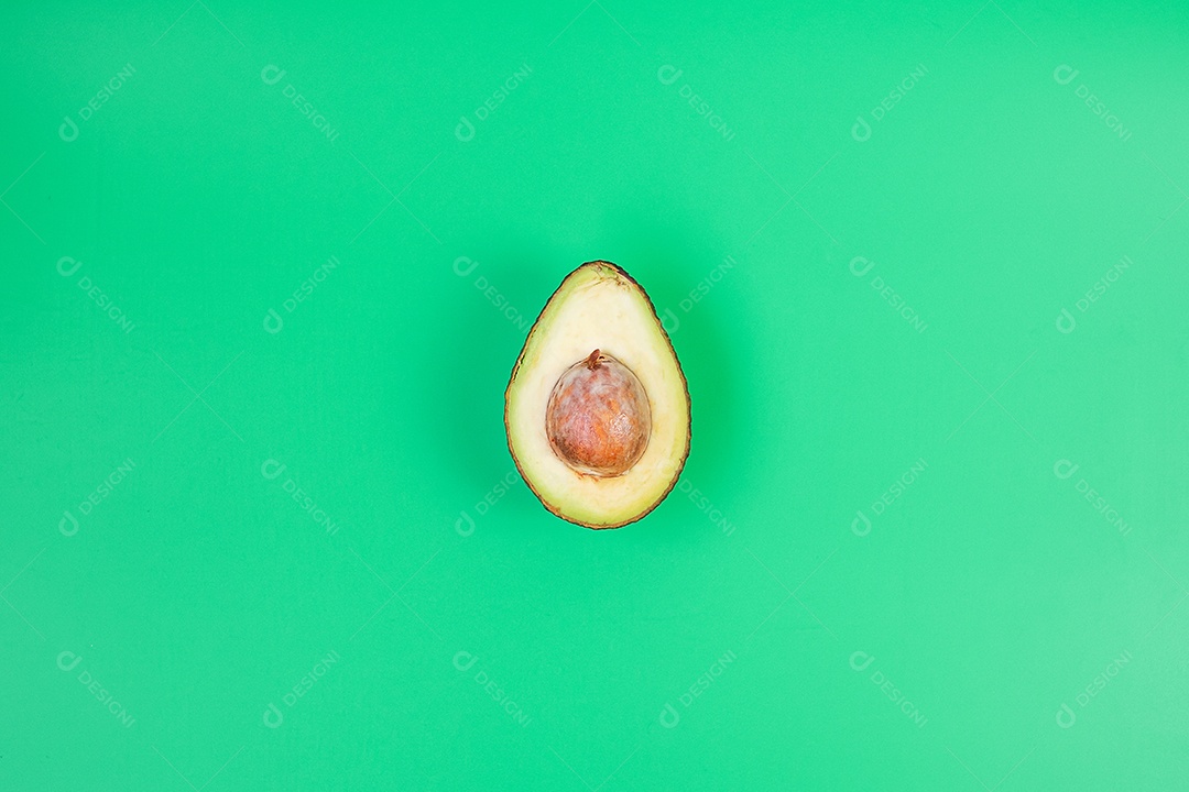 Abacate orgânico com sementes sobre fundo verde. Superalimento, frutas, comida saudável, dieta Keto e conceito vegetariano