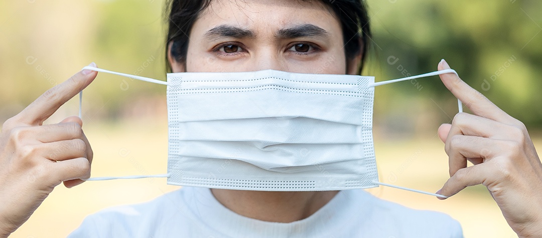 Mulher adulta jovem usando máscara facial protetora durante o alongamento muscular no parque ao ar livre