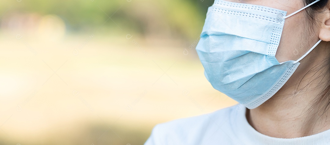 Mulher adulta jovem usando máscara facial protetora durante o alongamento muscular no parque ao ar livre