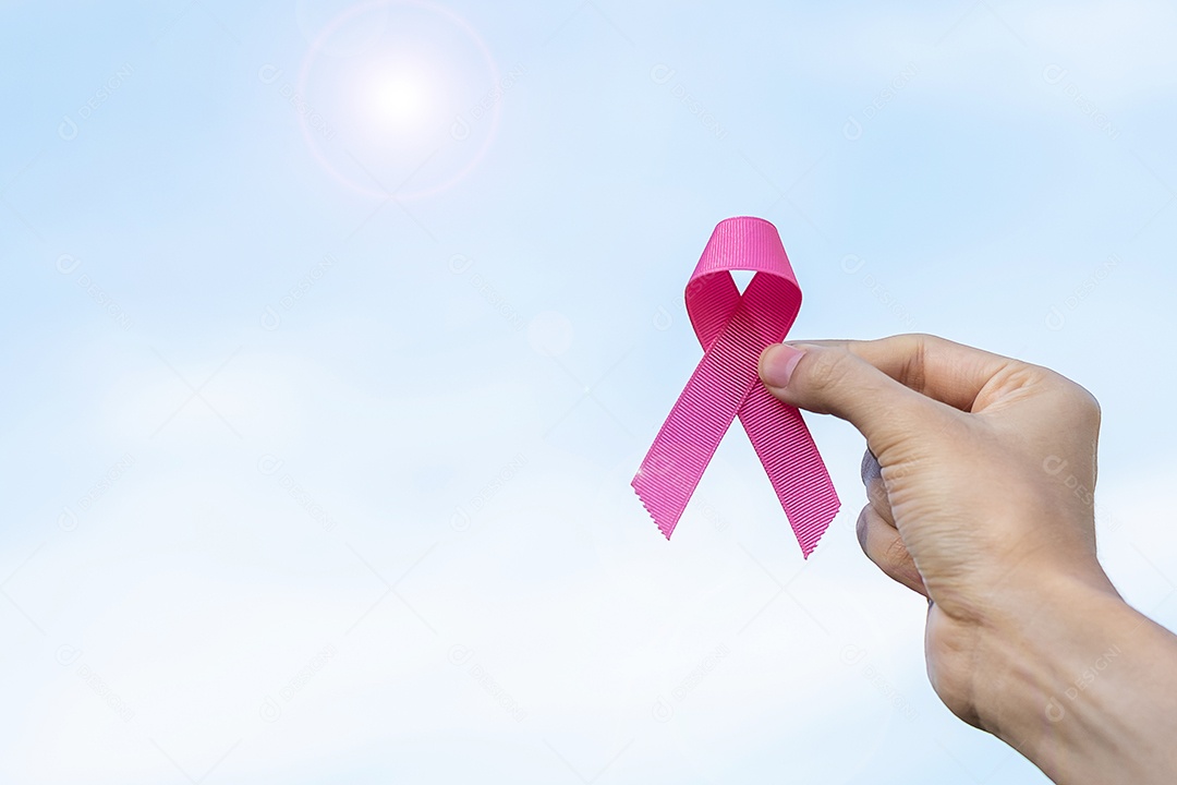 Mês de conscientização do câncer de mama de outubro, mão de mulher adulta segurando a fita rosa para apoiar as pessoas que vivem e estão doentes