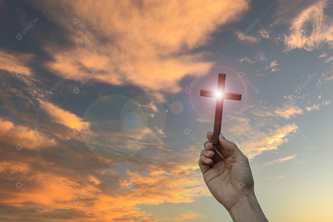 Silhueta mão segurando a cruz de madeira contra o fundo do nascer do sol, palma aberta para cima adoração, orar por bênçãos de Deus