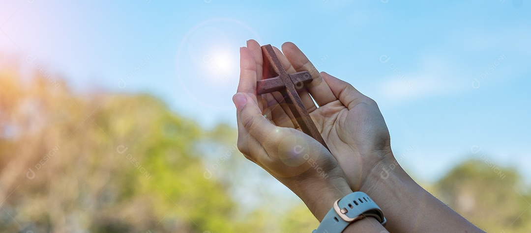 Silhouette hand holding wooden cross against sunrise background, open palm upward worship, pray for blessings from God