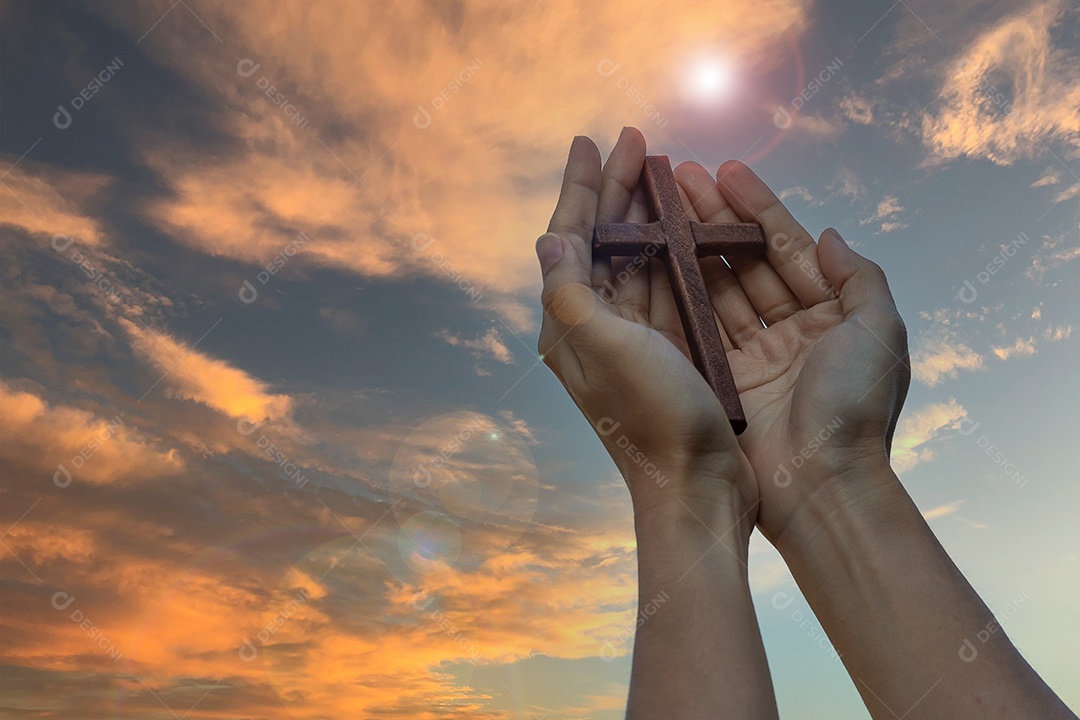 Silhueta mão segurando a cruz de madeira contra o fundo do nascer do sol, palma aberta para cima adoração, orar por bênçãos de Deus. Conceito cristão de religião, crucifixo e fé