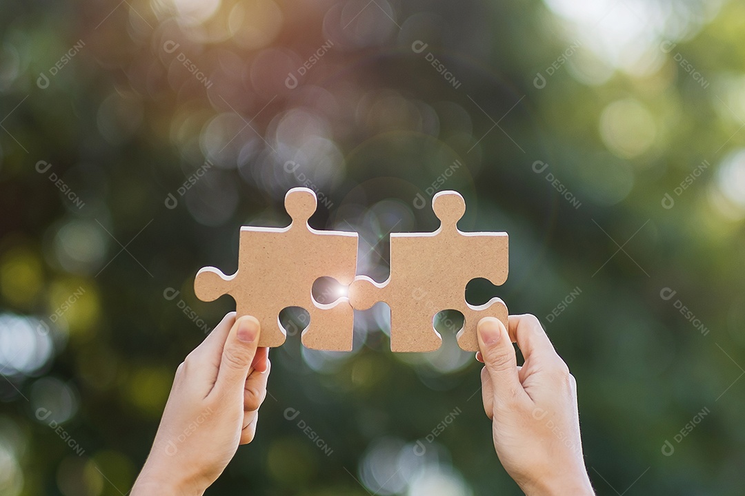 Mãos de mulher conectando a peça do quebra-cabeça de casal contra o efeito do nascer do sol, empresária segurando o quebra-cabeça