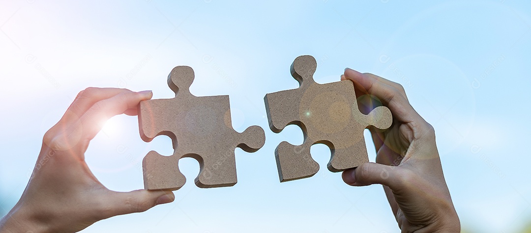 Mãos de mulher conectando a peça do quebra-cabeça de casal contra o efeito do nascer do sol, empresária segurando o quebra-cabeça