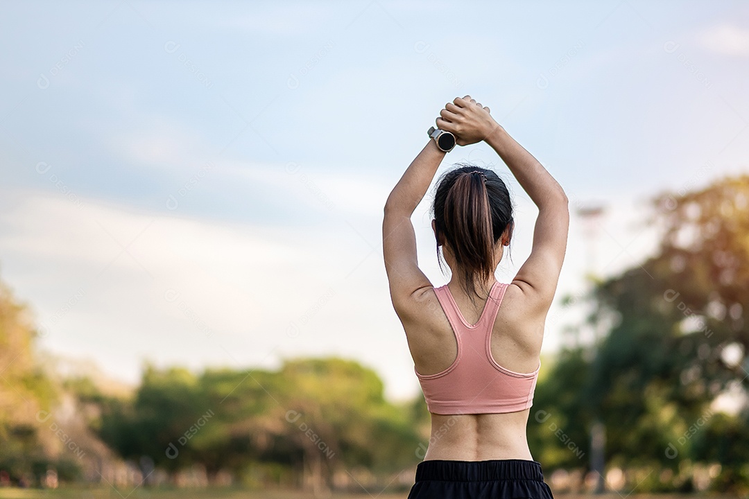 Mulher adulta jovem em sportswear rosa esticando o músculo no parque ao ar livre, esporte mulher aquecer pronto para correr e correr de manhã