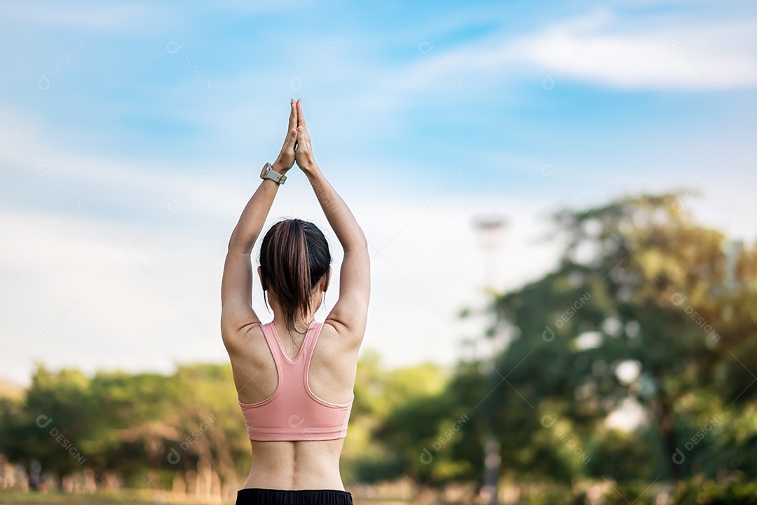 Mulher adulta jovem em sportswear rosa esticando o músculo no parque ao ar livre, esporte mulher aquecer pronto para correr e correr de manhã