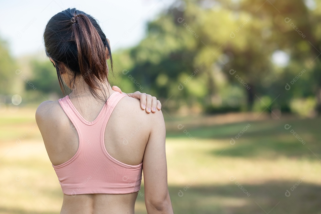 Mulher jovem fitness segurando seu ombro de lesão esportiva, músculo doloroso durante o treinamento