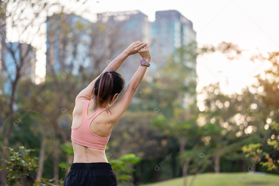Mulher adulta jovem em sportswear rosa esticando o músculo no parque ao ar livre, esporte mulher aquecer pronto para correr e correr de manhã