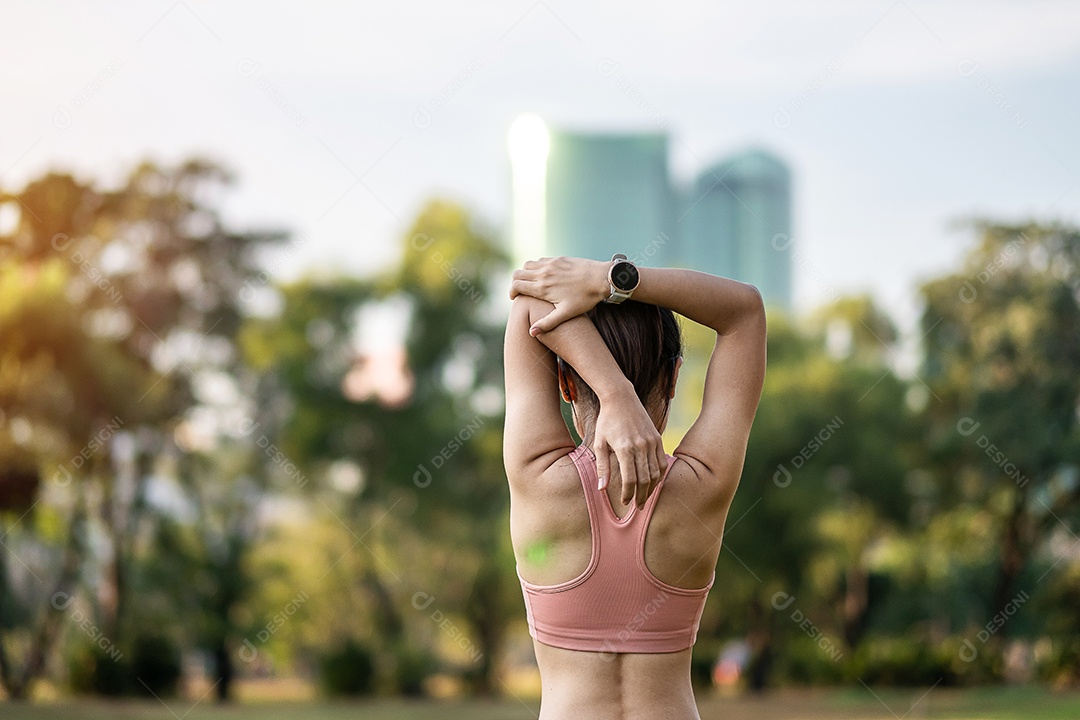Mulher adulta jovem em sportswear rosa esticando o músculo no parque ao ar livre, esporte mulher aquecer pronto para correr e correr de manhã