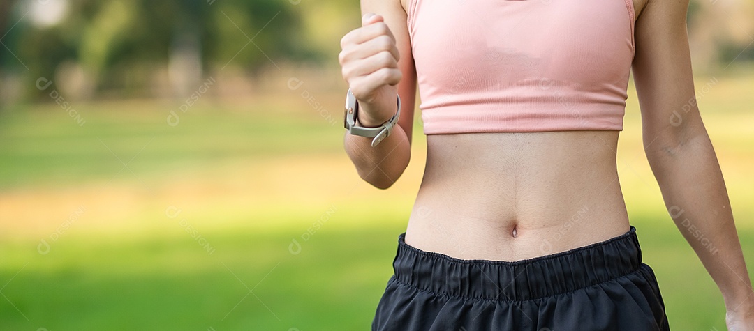 Mulher adulta jovem em sportswear rosa esticando o músculo no parque ao ar livre, esporte mulher aquecer pronto para correr e correr de manhã