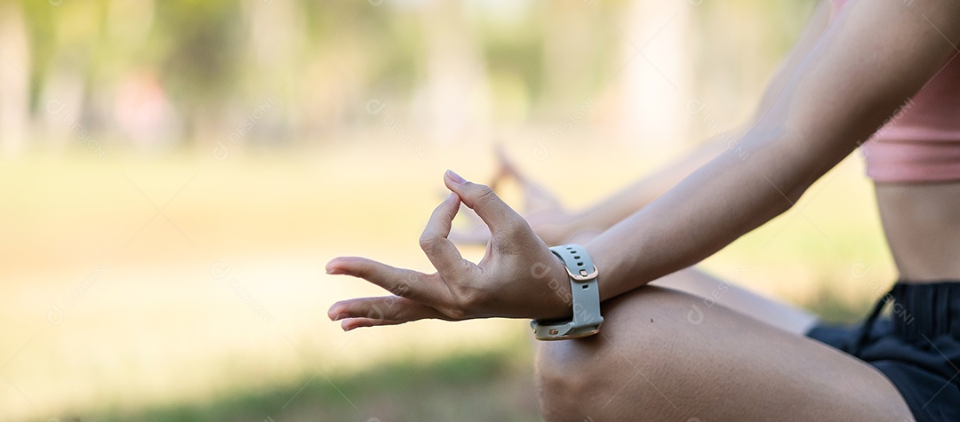 Mulher adulta jovem em roupas esportivas fazendo Yoga no parque ao ar livre, mulher saudável sentada na grama e meditação com pose de lótus de manhã