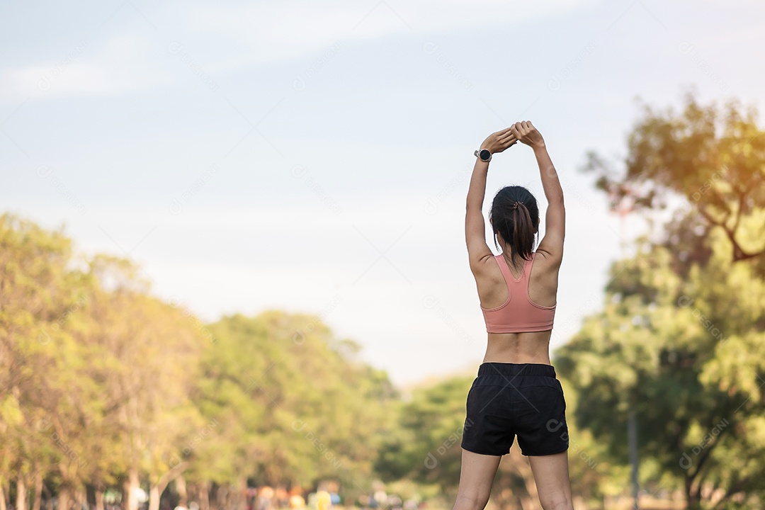 Mulher adulta jovem em sportswear rosa esticando o músculo no parque ao ar livre, esporte mulher aquecer pronto para correr e correr de manhã