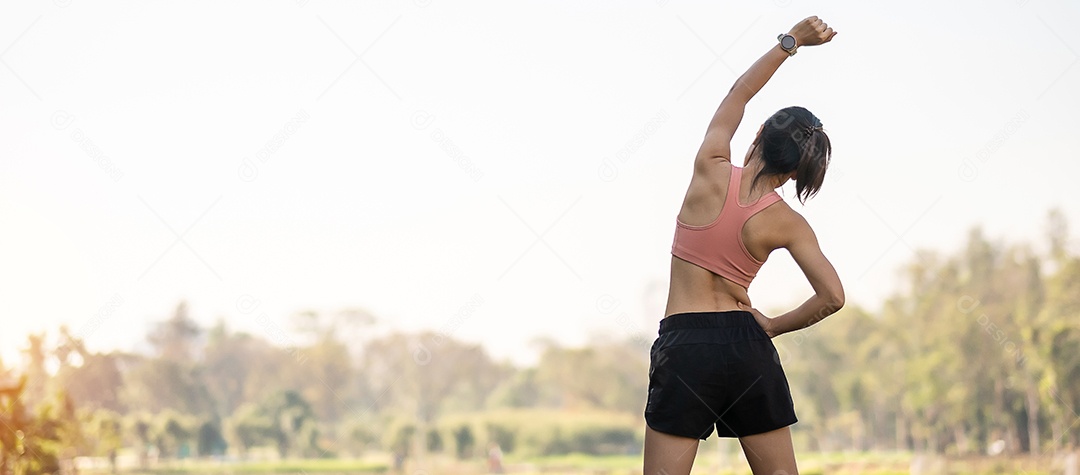 Mulher adulta jovem em sportswear rosa esticando o músculo no parque ao ar livre, esporte mulher aquecer pronto para correr e correr de manhã